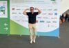 Outdoor-Fitness auf der GaLaBau 2026: Was Garten, Golfplatz und Spielplatz mit Deinem Training zu tun haben Michael Leibrecht vor der Wand des Grün-Blauen Pfads auf der GaLaBau 2026 in Nürnberg