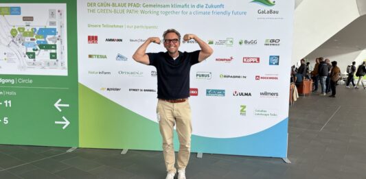 Outdoor-Fitness auf der GaLaBau 2026: Was Garten, Golfplatz und Spielplatz mit Deinem Training zu tun haben Michael Leibrecht vor der Wand des Grün-Blauen Pfads auf der GaLaBau 2026 in Nürnberg