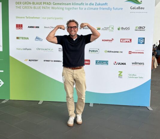 Outdoor-Fitness auf der GaLaBau 2026: Was Garten, Golfplatz und Spielplatz mit Deinem Training zu tun haben Michael Leibrecht vor der Wand des Grün-Blauen Pfads auf der GaLaBau 2026 in Nürnberg
