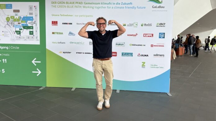 Michael Leibrecht vor der Wand des Grün-Blauen Pfads auf der GaLaBau 2026 in Nürnberg