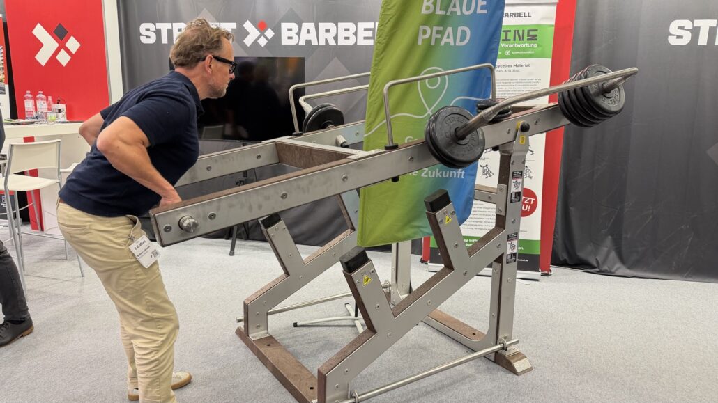 Michael Leibrecht an einem Outdoor-Kraftgerät mit Hantelscheiben am Stand von Street Barbell auf der GaLaBau 2026
