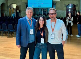 Hans Münch: 45 Jahre Fitnessmarkt, 12 Lektionen für Dein Fitnessstudio Hans Münch, Iris Leibrecht und Michael Leibrecht vor der Sponsorenwand des HFA-Europakongresses