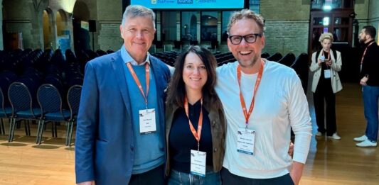 Hans Münch: 45 Jahre Fitnessmarkt, 12 Lektionen für Dein Fitnessstudio Hans Münch, Iris Leibrecht und Michael Leibrecht vor der Sponsorenwand des HFA-Europakongresses